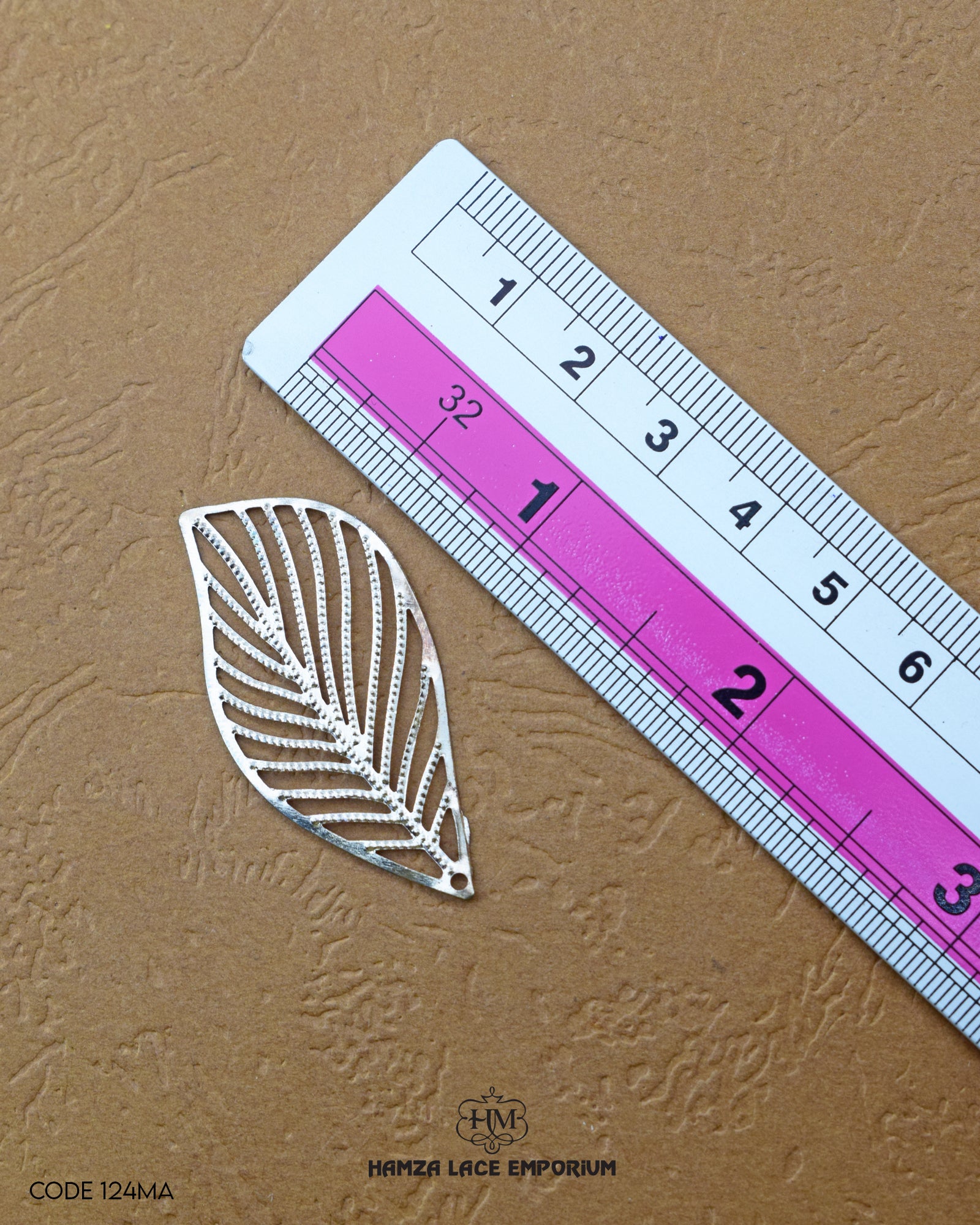 The 'Leaf Design Metal Accessory MA124' size is showcased using a ruler for precise measurement.