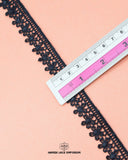 A ruler is on the 'Edging Flower Lace 16174' measuring its size as  one inch