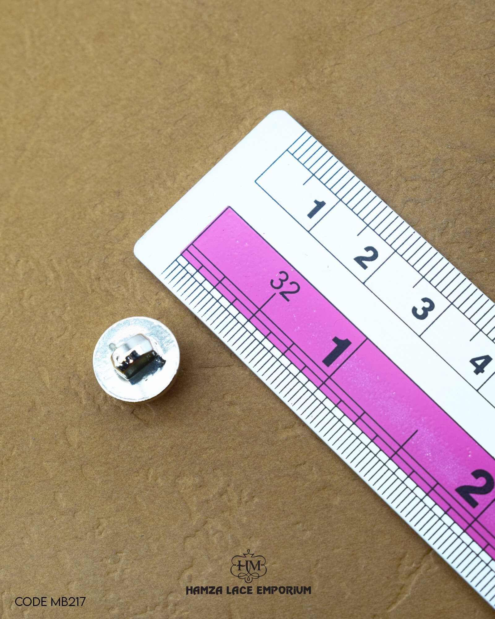 Size of the 'Loop Shape Plastic Button MB217' is given with the help of a ruler