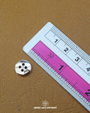 The dimensions of the 'Four Hole Plastic Button MB224' are determined using a ruler.