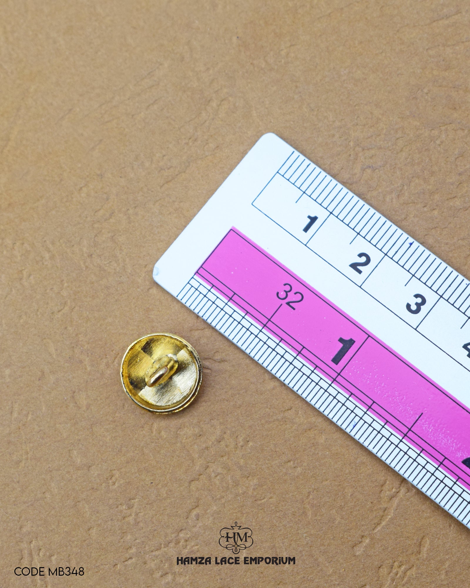 The dimensions of the 'Golden Metal Button MB348' are determined using a ruler.