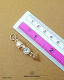 The dimensions of the 'Golden Hanging Metal Button MB506' are determined using a ruler.