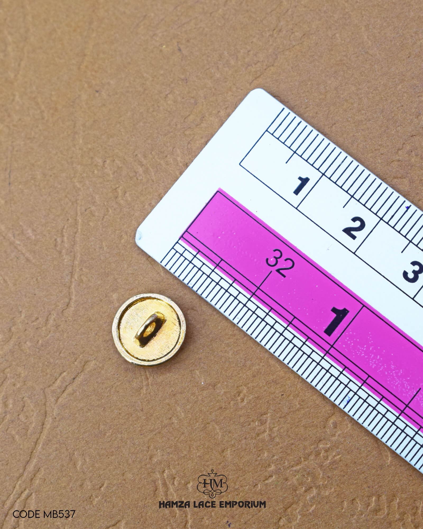 The size of the 'Metal Suiting Button MB537' is measured by using a ruler