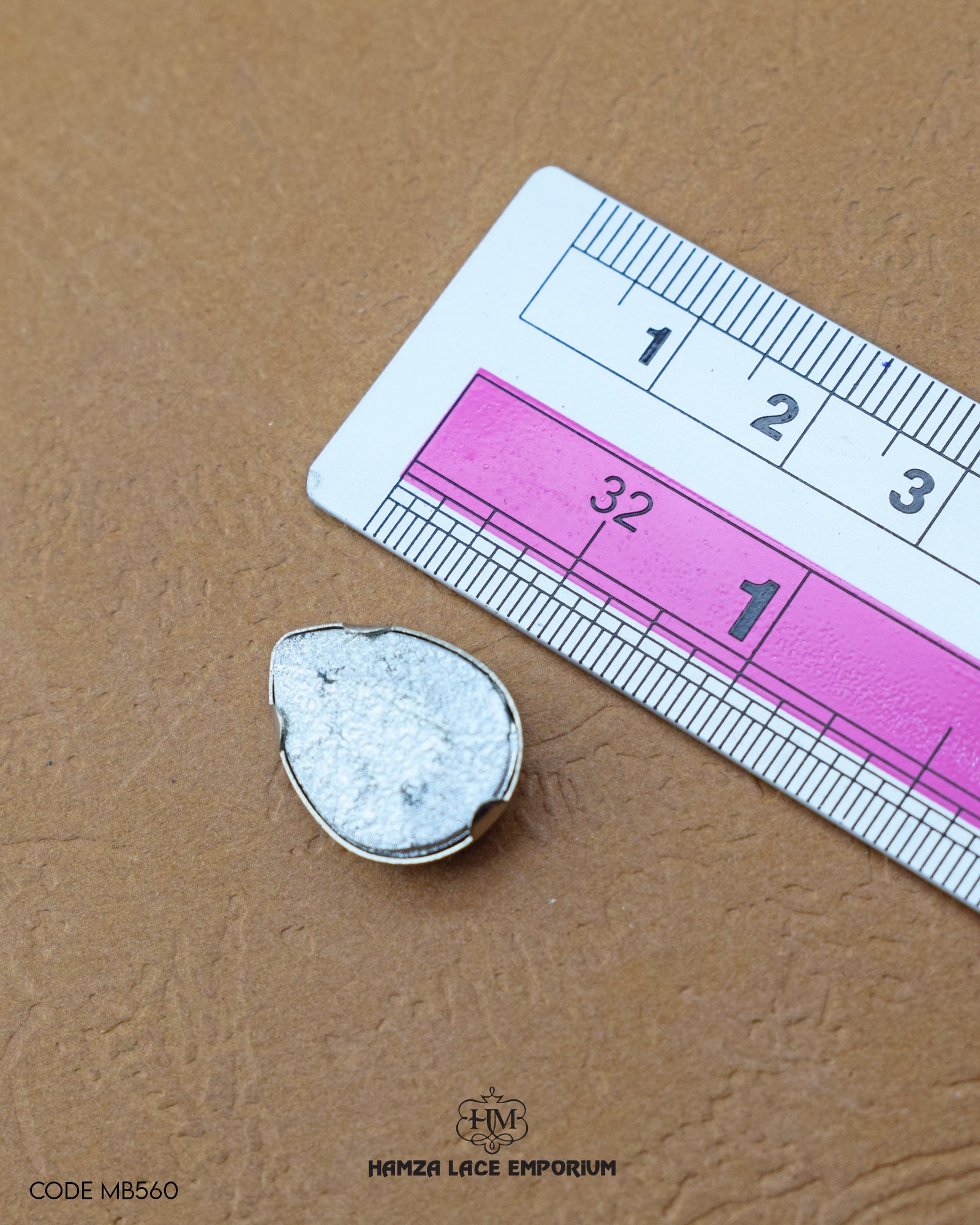 The size of the 'Metal Button MB560' is measured using a ruler.