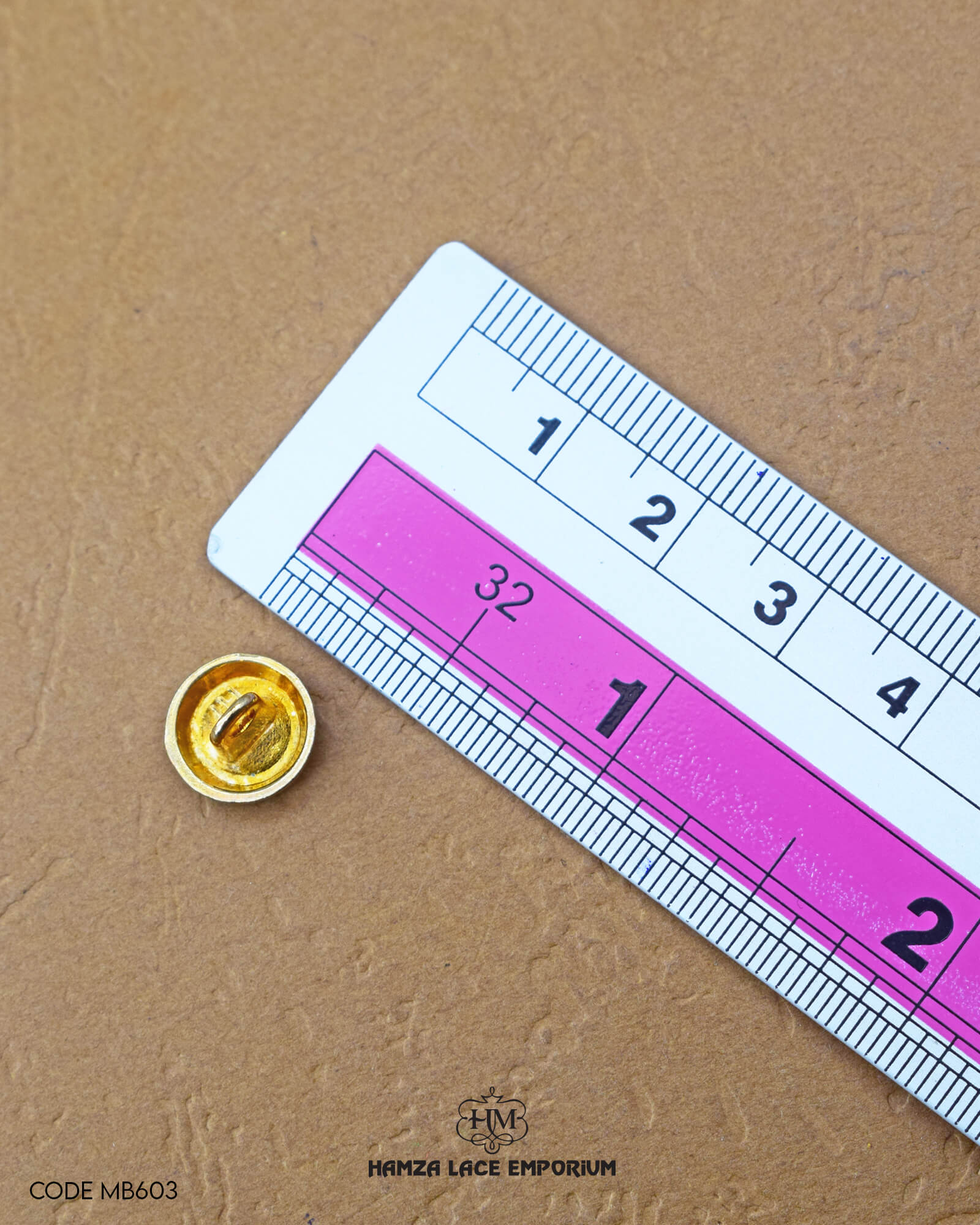 The size of the 'Metal Suiting Button MB603' is measured using a ruler.