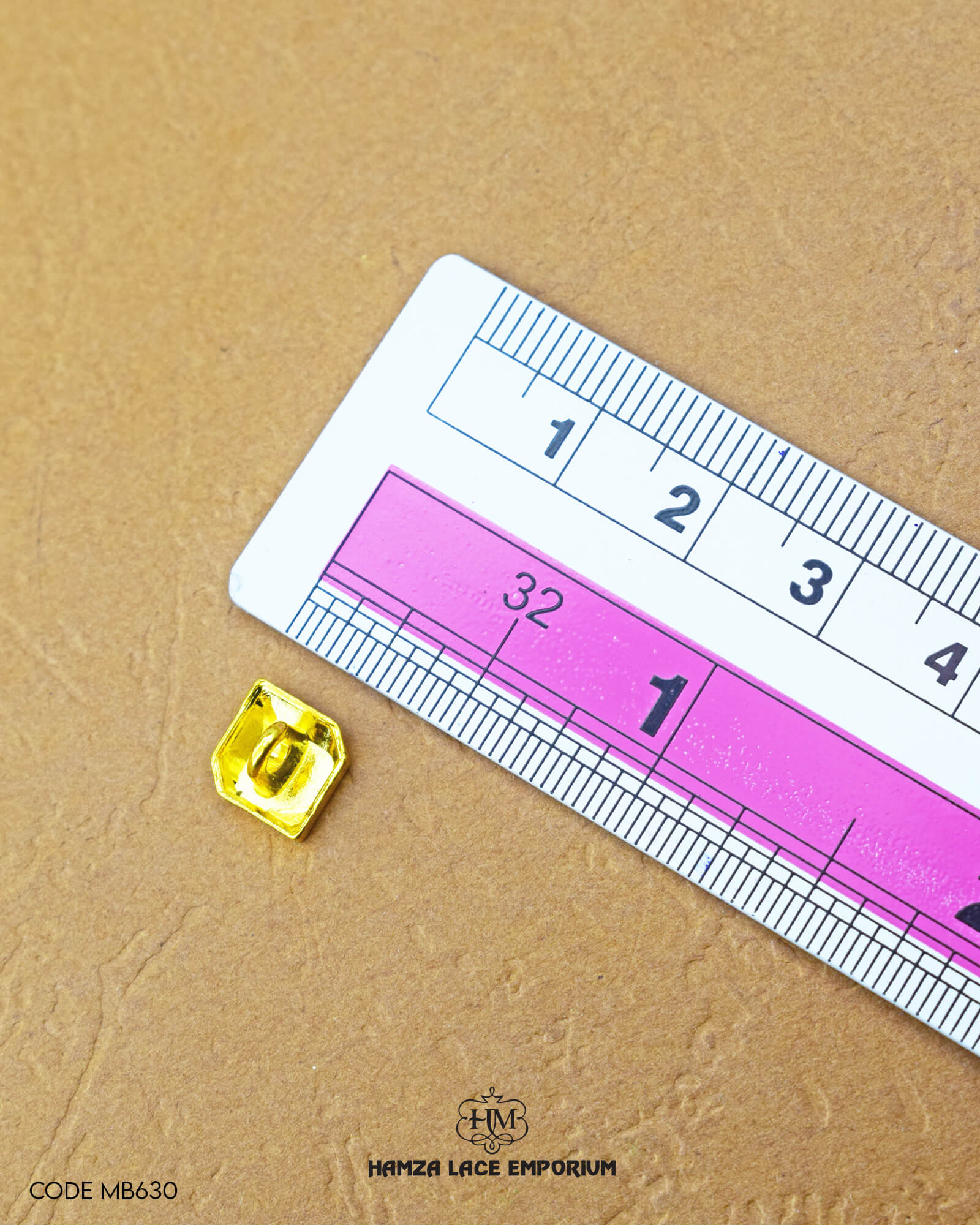 The dimensions of the 'Metal Suiting Button MB630' are determined using a ruler.