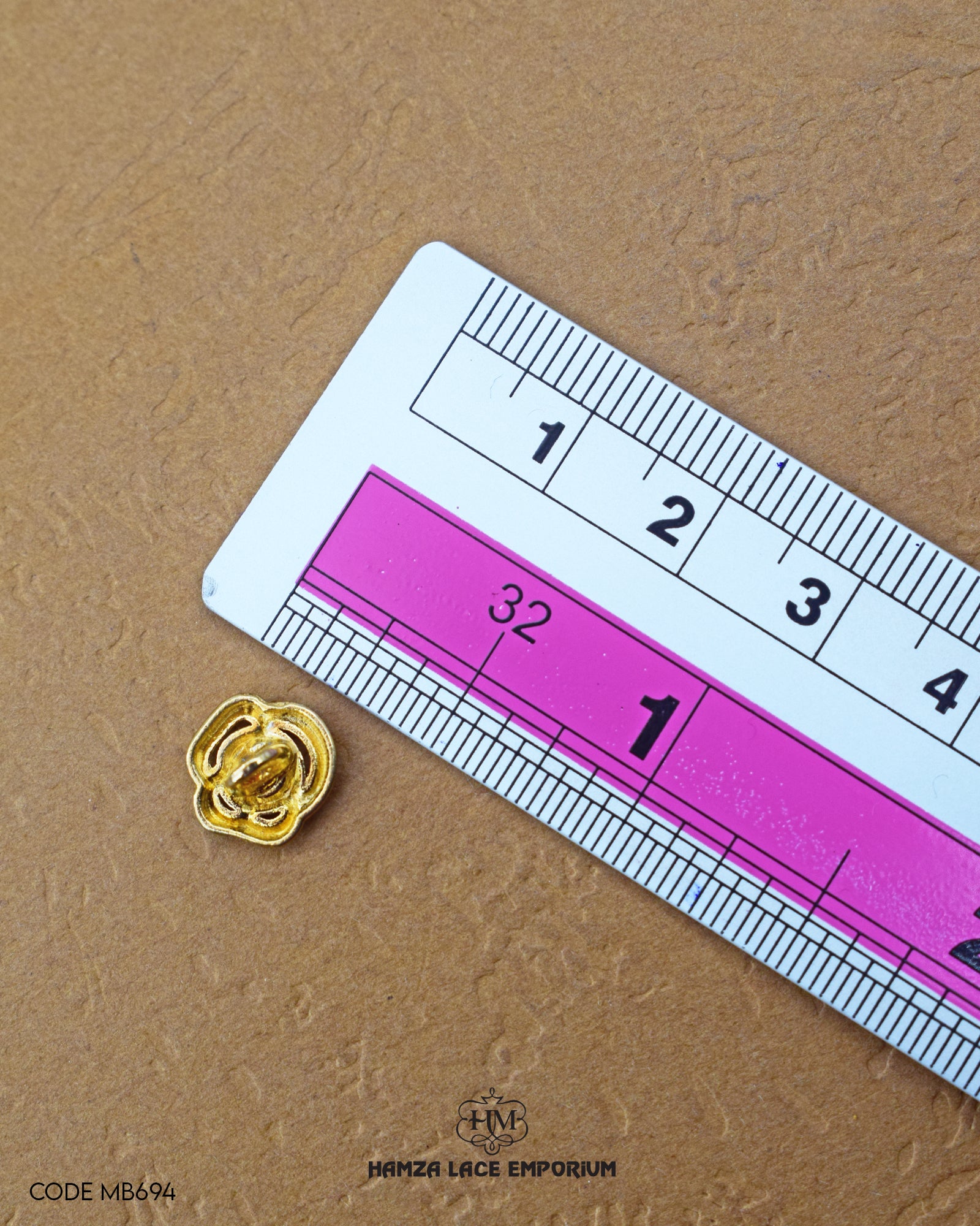Size of the 'Flower Design Metal Button MB694' is given with the help of a ruler