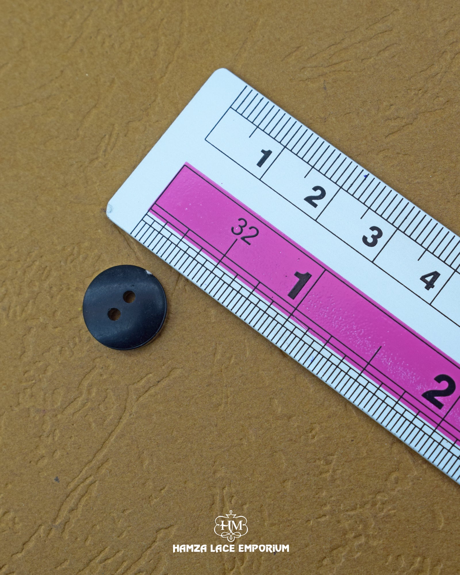The dimensions of the 'Star Design Plastic Button MB837' are determined using a ruler.