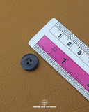 The dimensions of the 'Two Hole Black Plastic Button MB841' are determined using a ruler.