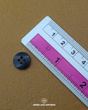 The dimensions of the 'Double Shade Plastic Button MB845' are determined using a ruler.