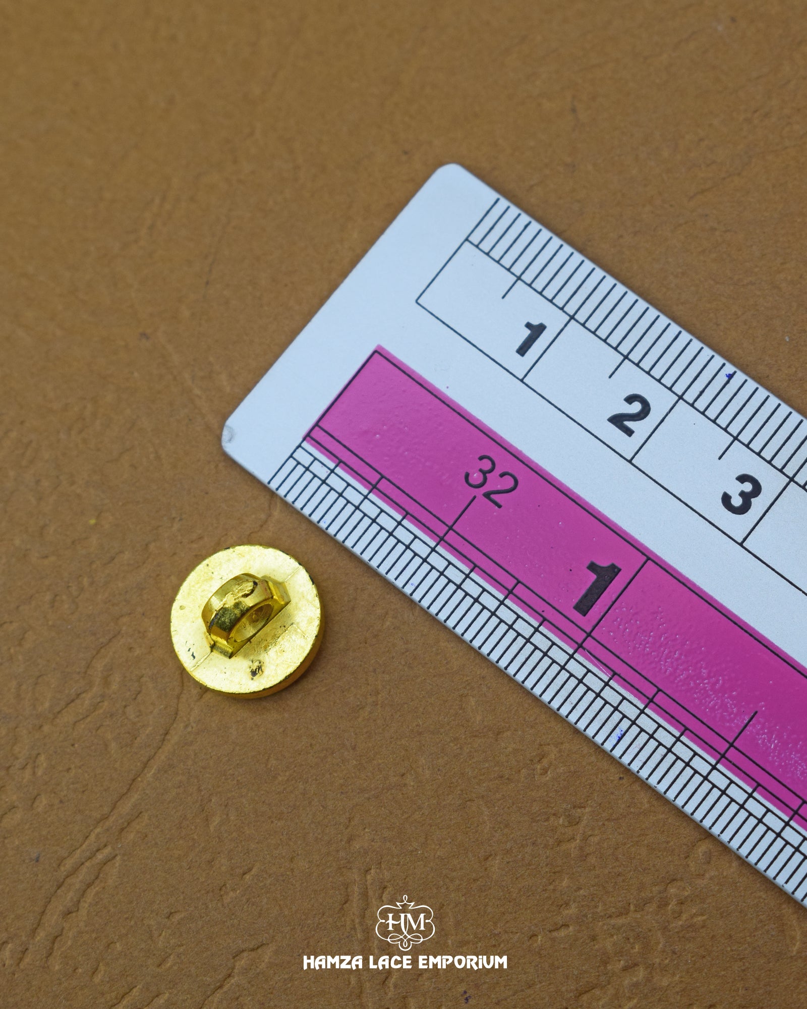 The size of the 'Golden Metal Button MB857' is measured using a ruler.
