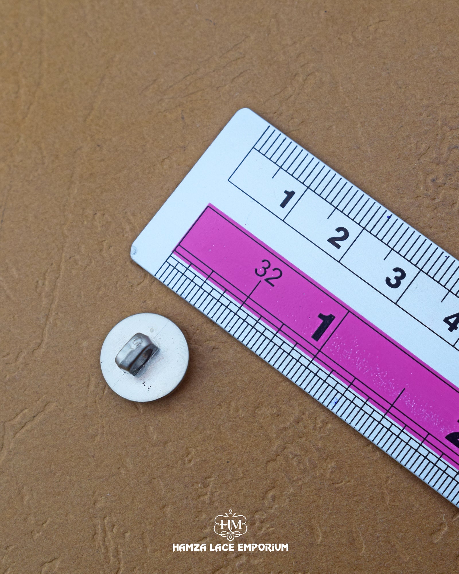 The size of the 'Metal Suiting Button MB859' is measured using a ruler.