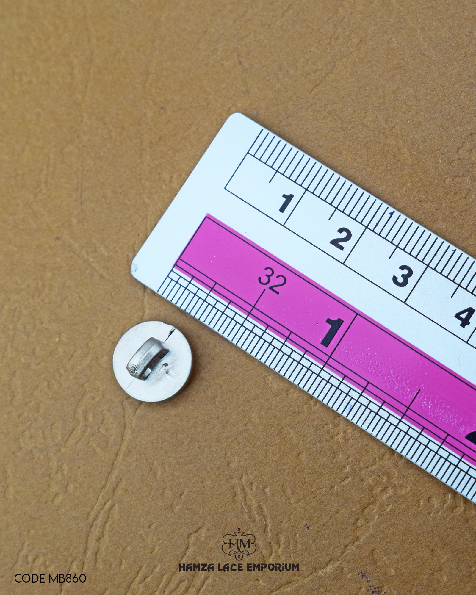 The dimensions of the 'Silver Metal Button MB860' are determined using a ruler.