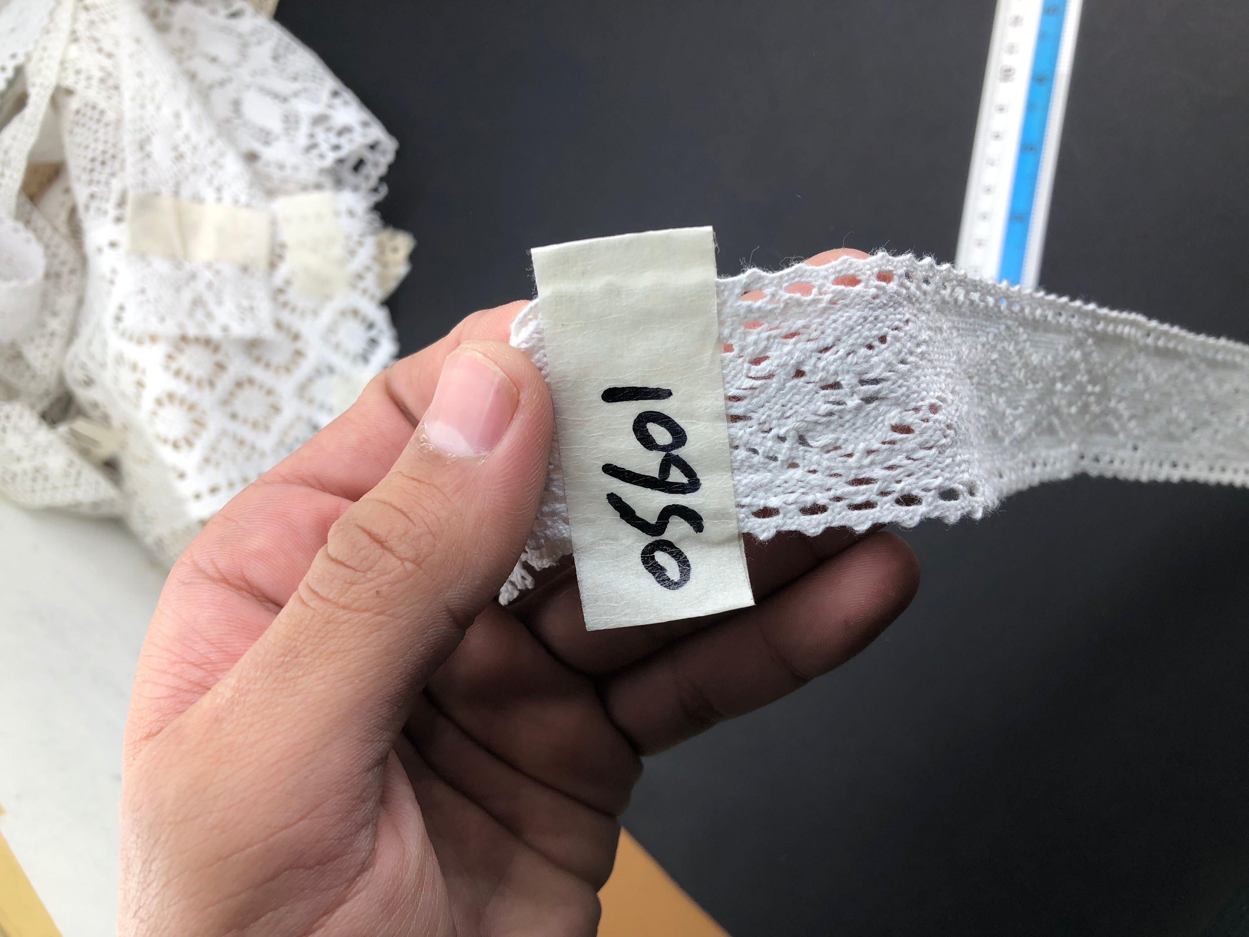 A man is holding a piece of 'Center Filling Crochet Lace 21810'